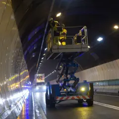 Pracownicy na podnośniku w tunelu Frejus montują nowe oświetlenie.