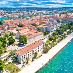 Widok na Zadar z lotu ptaka: czerwone dachy, turkusowe morze i nowoczesne budynki. Ceny w Zadarze zachęcają do odwiedzin.