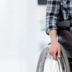 Osoba na wózku inwalidzkim, zastanawiająca się, czy opiekun osoby niepełnosprawnej może pracować.