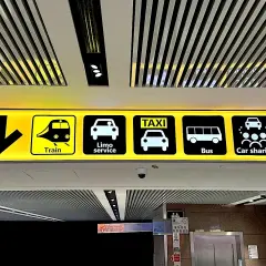 Znaki na lotnisku Fiumicino w Rzymie: pociąg, limuzyna, taxi, autobus, car sharing.