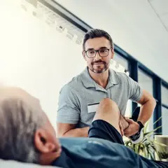 Fizjoterapeuta pomaga pacjentowi w ćwiczeniach. To pokazuje, jak zostać fizjoterapeutą i pomagać innym w powrocie do zdrowia.