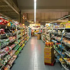 Długie alejki pełne kolorowych opakowań, typowe dla **Holandii sklepy** spożywcze. Widać mnóstwo przekąsek, słodyczy i produktów instant.