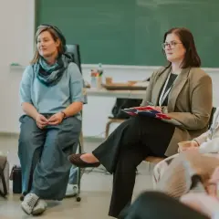 Grupa osób siedzi w kręgu, dyskutując o tym, ile zarabia wychowawca w domu dziecka.