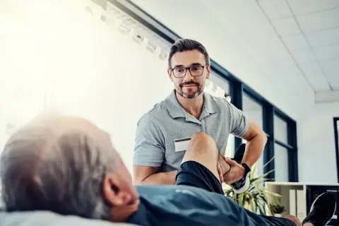 Fizjoterapeuta pomaga pacjentowi w ćwiczeniach. To pokazuje, jak zostać fizjoterapeutą i pomagać innym w powrocie do zdrowia.