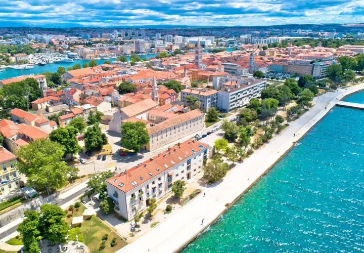 Widok na Zadar z lotu ptaka: czerwone dachy, turkusowe morze i nowoczesne budynki. Ceny w Zadarze zachęcają do odwiedzin.