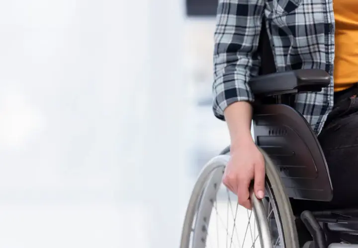 Osoba na wózku inwalidzkim, zastanawiająca się, czy opiekun osoby niepełnosprawnej może pracować.