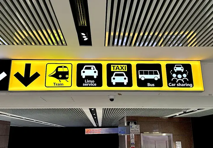Znaki na lotnisku Fiumicino w Rzymie: pociąg, limuzyna, taxi, autobus, car sharing.