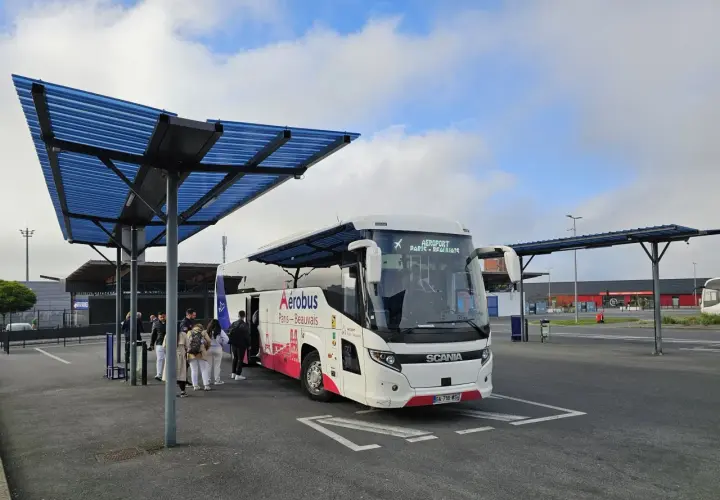 Autobus Aerobus Paris-Beauvais czeka na pasażerów pod niebieskim zadaszeniem.