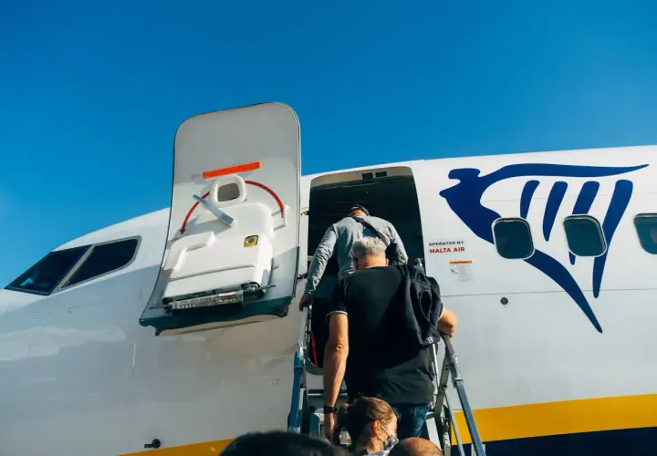 Ludzie wsiadają do samolotu Ryanair. Płatność przelewem za bilety była prosta, teraz czas na podróż!