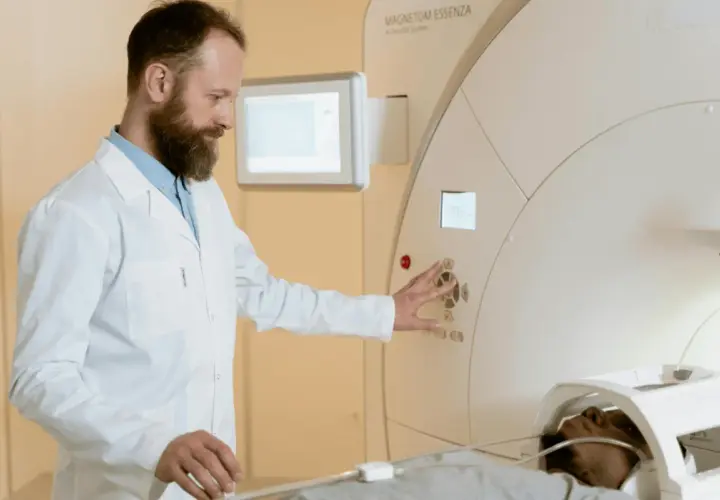 Technik elektroradiolog zarobki: specjalista obsługuje aparat MRI, dbając o pacjenta i badanie.