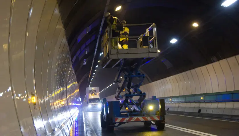 Pracownicy na podnośniku w tunelu Frejus montują nowe oświetlenie.