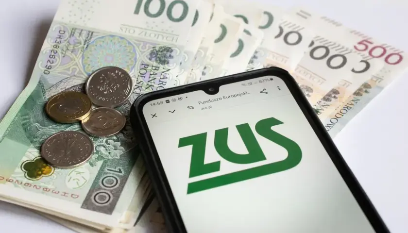 Pieniądze i telefon z logo ZUS. Czy to odzwierciedla, ile zarabia opiekun medyczny w hospicjum?