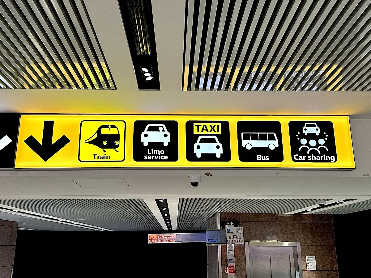 Znaki na lotnisku Fiumicino w Rzymie: pociąg, limuzyna, taxi, autobus, car sharing.
