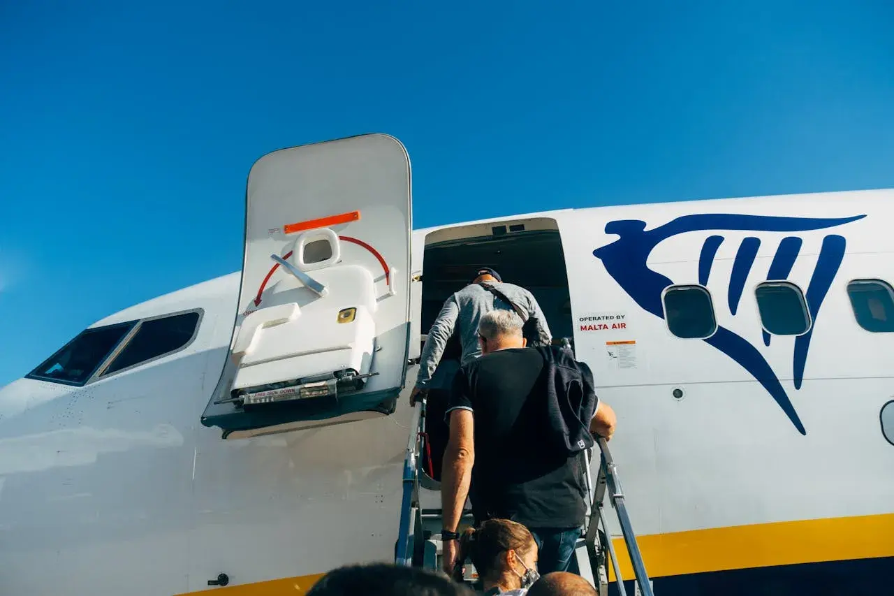 Ludzie wsiadają do samolotu Ryanair. Płatność przelewem za bilety była prosta, teraz czas na podróż!