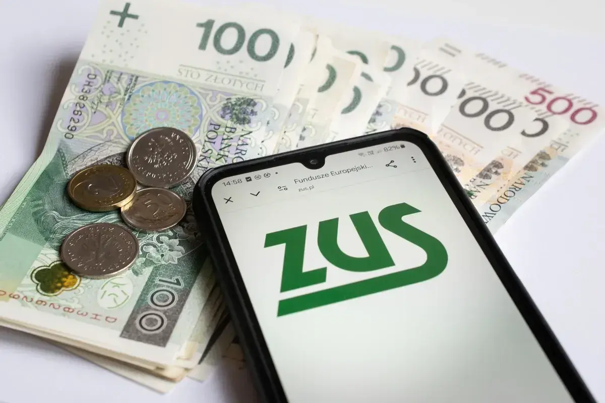Pieniądze i telefon z logo ZUS. Czy to odzwierciedla, ile zarabia opiekun medyczny w hospicjum?
