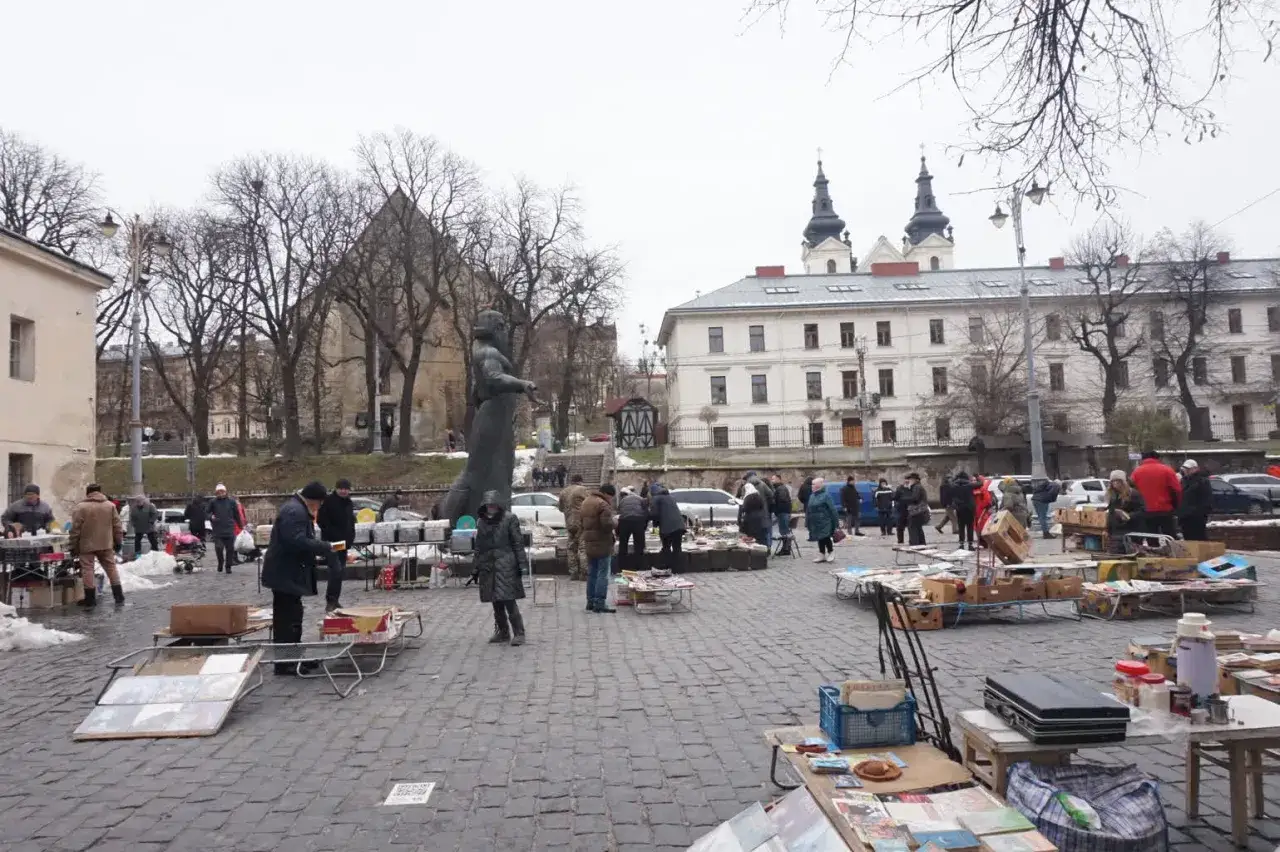 Targ staroci we Lwowie. Ludzie oglądają przedmioty, szukając okazji. Ceny są r&oacute;żne, od niskich po wyższe.